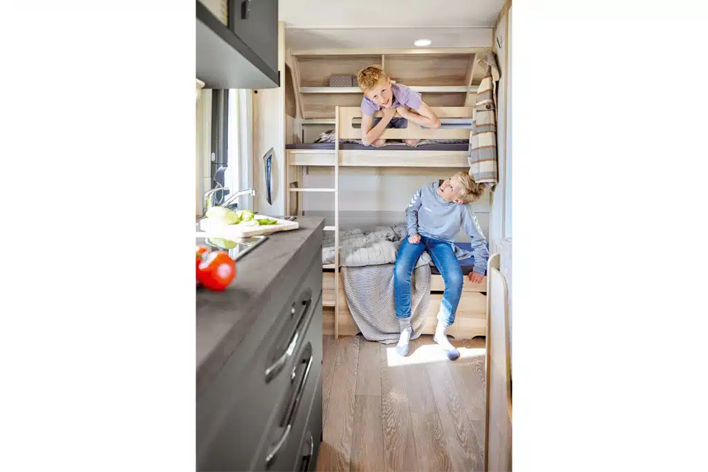 Zwei Kinder in Stockbetten im Wohnwagen Hobby De Luxe
